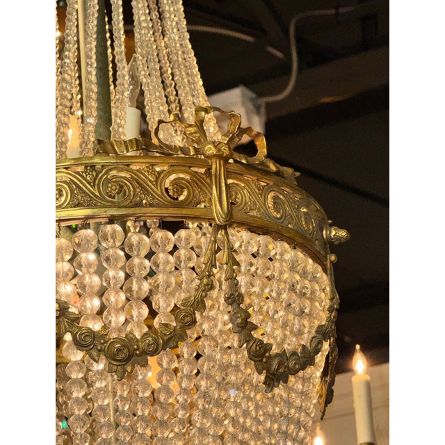 The French Empire Gilt Bronze and Crystal Basket Chandelier is a luxurious and elegant light fixture. Featuring beautiful...
