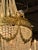 The French Empire Gilt Bronze and Crystal Basket Chandelier is a luxurious and elegant light fixture. Featuring beautiful...