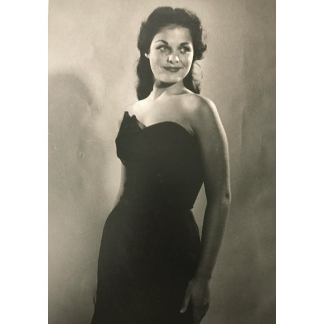 Vintage black and white photograph of a woman in a formal gown C. 1950's. Glued down to backing mat.