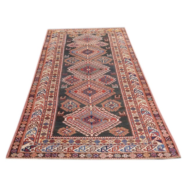 The dark olive field displays an expansive pole medallion of five, layered, densely hooked diamonds, with small supporting...