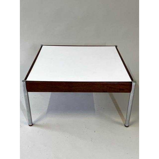 Scandinavian coffee table produced in the 1960s. Round chrome plated legs combined with teak details and a white laminate...
