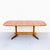 Scandinavian mid century modern expandable teak dining table by D Scan. The surfboard-shaped tabletop rests on a softly...