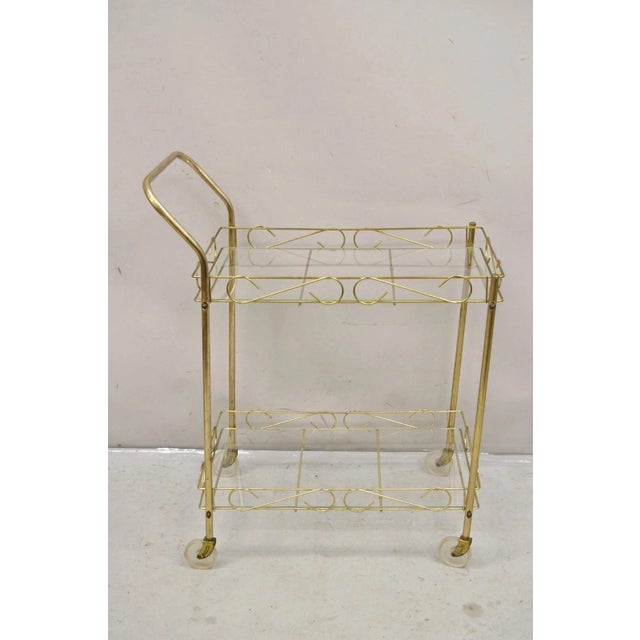 Vintage Mid Century Modern Gold Metal 2 Tier Rolling Bar Tea Cart Server. Circa Mid 20th Century. Measurements: 35" H x...