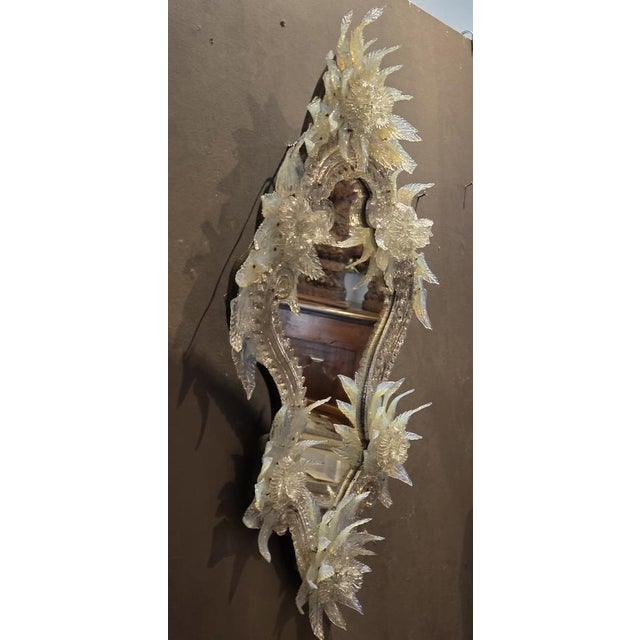 Elegant Venetian mirror from the late nineteenth century, enriched by a rich decoration of flowers and leaves in blown and...