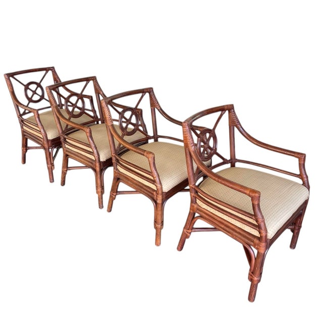 A set of four 1990s vintage rattan arm chairs manufactured by Shelby Williams. Target backs in the style of McGuire Four...