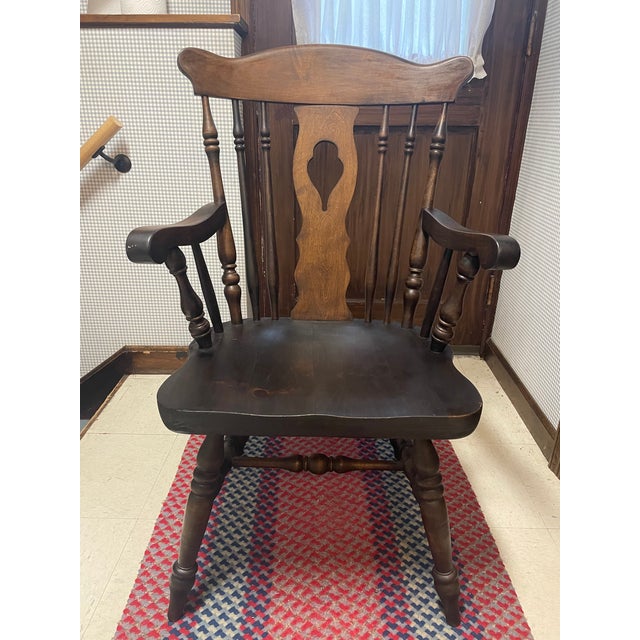 This is a mid 20th century Nichols & Stone arm chair. The Windsor style chair features a cut out center splat with spindle...