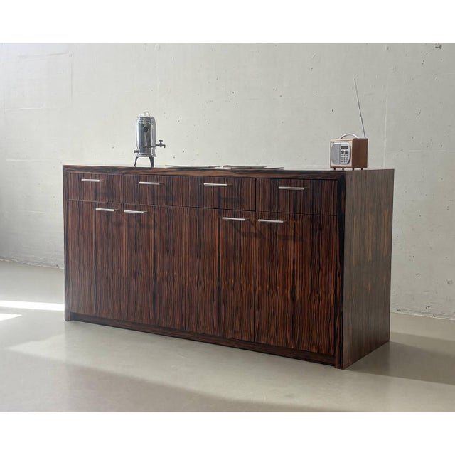Elegant vintage sideboard with a high-quality veneer in a striking Makassar wood look. The clean lines and the richly...