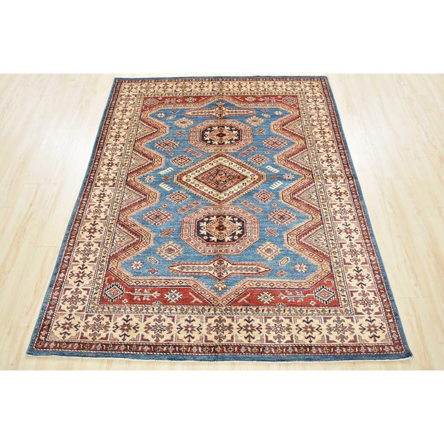 This fine traditional tribal geometric Caucasian Kazak rug is hand-knotted with an all-wool pile on a cotton foundation....