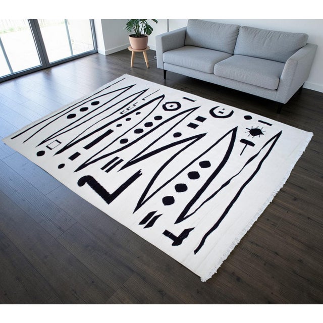 This authentic modern silk rug features an abstract expressionist design in deep white and charcoal, meticulously sized at...