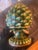 This decorative piece is crafted in the shape of a blooming artichoke, featuring realistic, layered leaf scales with a...