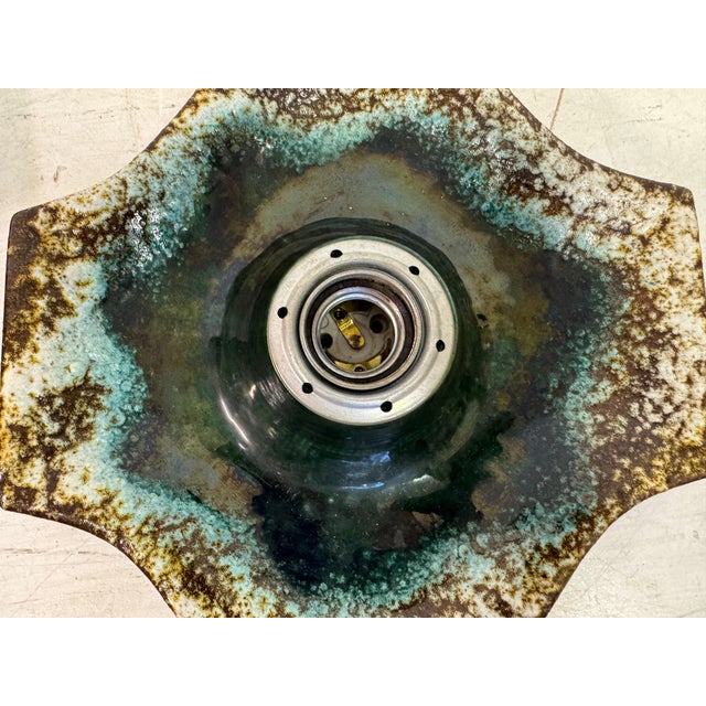 This 1960s wall light is a captivating German ceramic piece, showcasing the unique and artistic design sensibilities of...