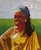 This artwork features a vibrant portrait of a figure adorned in traditional attire, skillfully rendered using thread and...