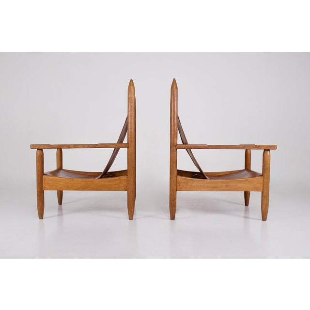 Pair of modernist armchairs in solid light oak and thick cognac leather, anonymous edition circa 1950. In very good...
