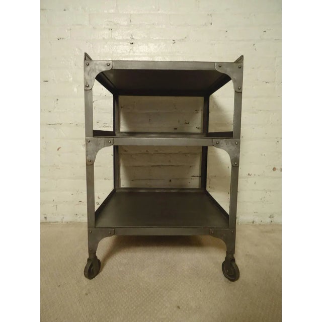 Metal shelving unit on casters restored in a bare metal style finish. Handsome industrial look with exposed rivets. Makes...