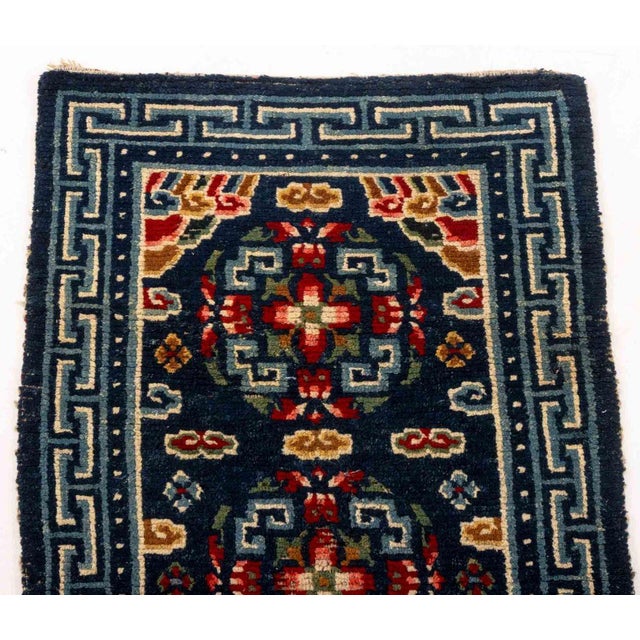 Tibetan Gyantse Wool Khaden Rug, with stylized floral motifs on a blue ground. 4' 4.5" L x 2' 3.5" W. Provenance: From the...