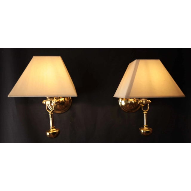 Heavy cast brass lamps are designed to be mounted on the wall of a boat. The lamps are perfectly balanced by a heavy...