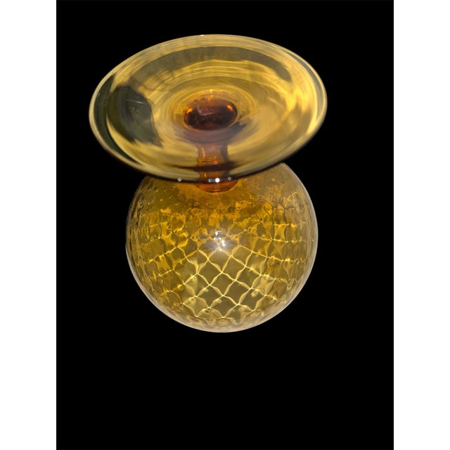 An oversized amber glass brandy snifter featuring a diamond optic pattern and a short pedestal stem. Produced in the...