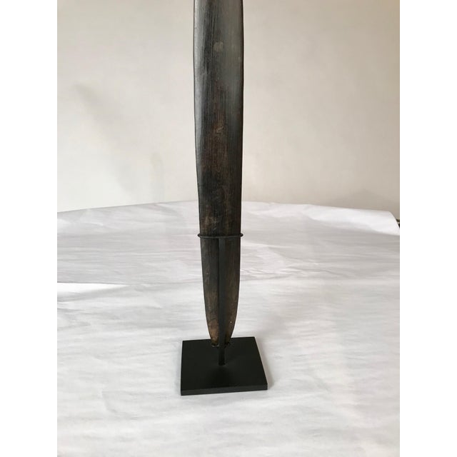 A Papua New Guinea hand carved ebony lime spatula covered with continuous swirl designs etched on the open handle and...