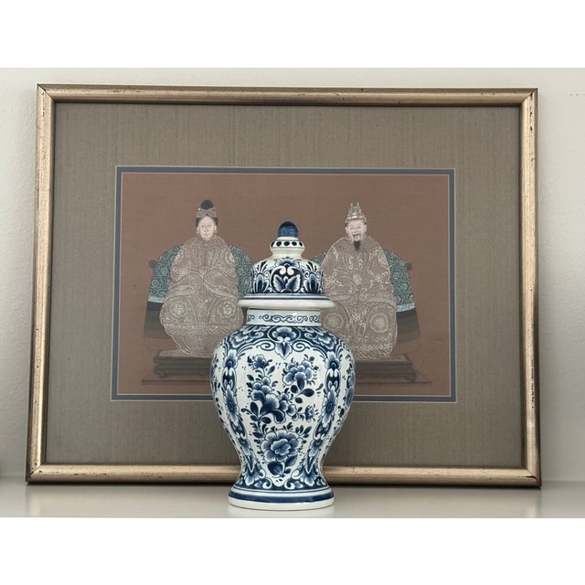 Vintage hand-painted Dutch Delft blue and white lidded vase featuring an elegant baluster form and richly detailed floral...