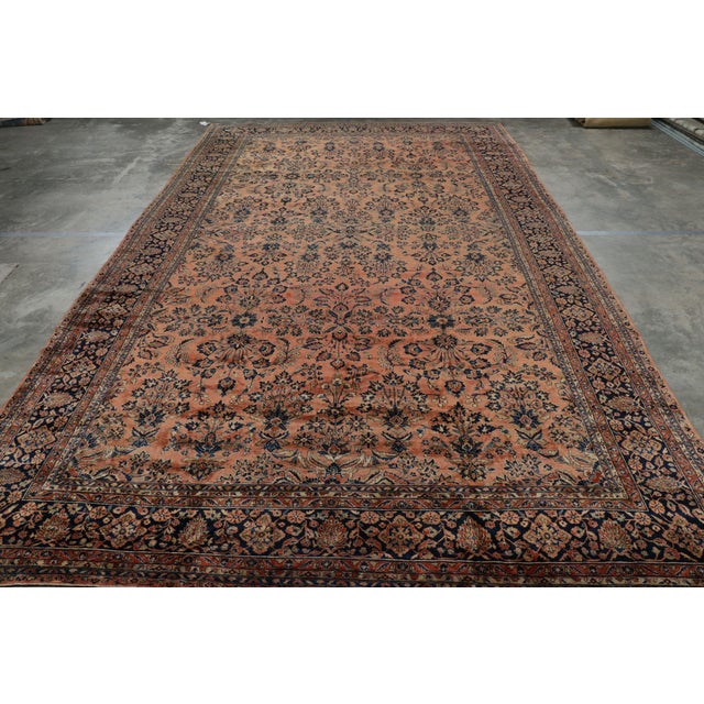 Hand-knotted in wool, this 12x21 antique Persian Sarouk rug originating circa 1920-1930, with intricate floral patterns,...