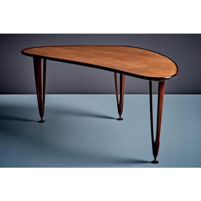 An elegant triangular teak coffee table by BC Møbler, Denmark, 1960s. This rare Scandinavian piece features an organically...