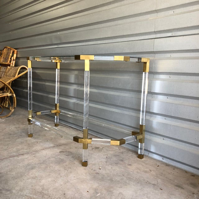 Lucite or acrylic brass console table attributed to Charles Hollis Jones. This console table or sofa table features two...