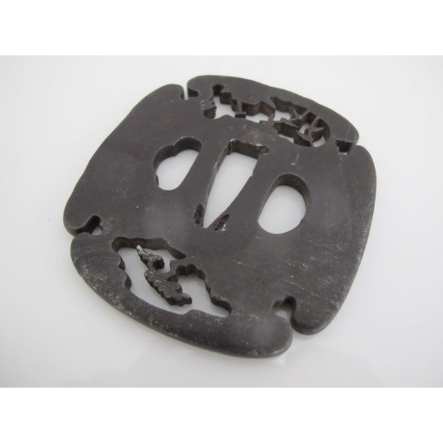 Antique Japanese hand forged iron Tsuba or sword hand guard. The tsuba would mounted between the sword's blade and grip to...