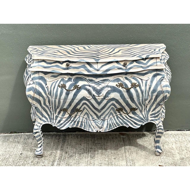 Bold, glamorous, and undeniably eye-catching, this vintage hand-painted bombe chest is a striking example of Hollywood...