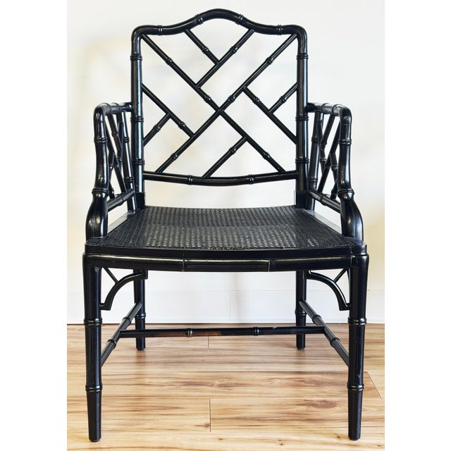 Vintage faux bamboo Chinoiserie Chippendale style arm chair with caned seat and generous proportions. Glossy black finish...
