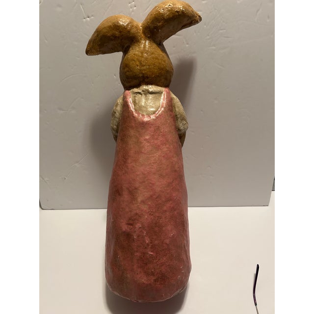 A beautiful paper mache Lady Bunny Rabbit, highlighted with crackle paint. She is holding an egg-shaped bag adorned with a...