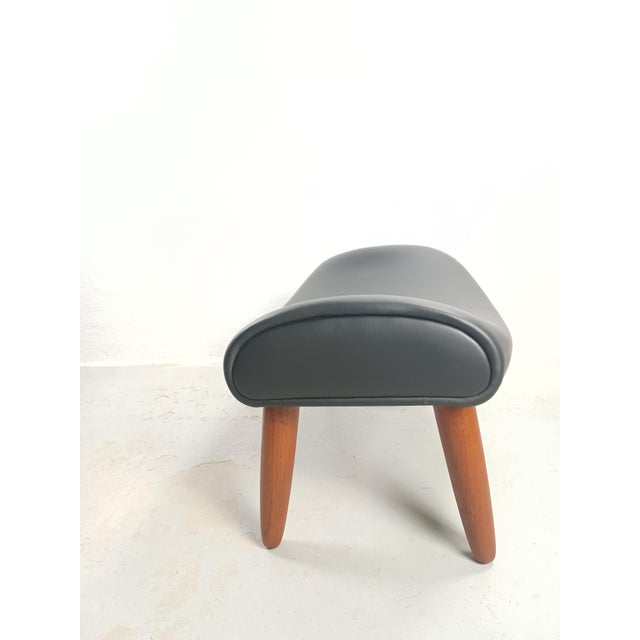 1950´s Reupholstered Danish ottoman in teak and black leather Danish ottoman from the 1960´s in solid teak with elegant...