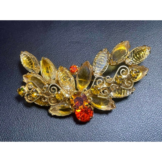 This DeLizza & Elster (Juliana) styled brooch features a distinctive mix of specialty art glass and crystal elements,...