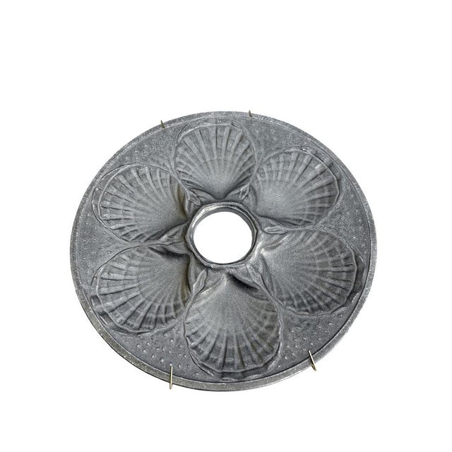 Vintage pewter oyster plate with six scallop-designed wells, ideal for wall decoration or serving seafood. Measures 9.5...