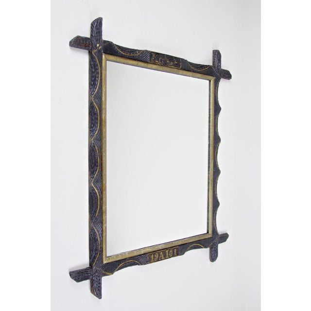 Peerless rustic wooden wall mirror from Austria, dated to 1901. A very special designed wall mirror with a golden bar on...