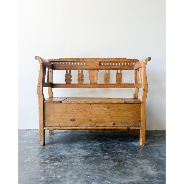 19th century antique European country pine settle bench featuring a waxed natural finish, and a spacious lift lid storage...