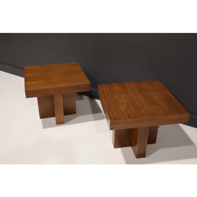 A pair of square cocktail occasional tables with refinished walnut tops and bases. In the Style of Milo Baughman,...