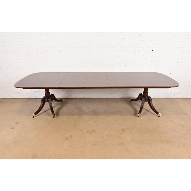 An exceptional Georgian or Regency style double pedestal extension dining table By Baker Furniture USA, Circa 1980s...
