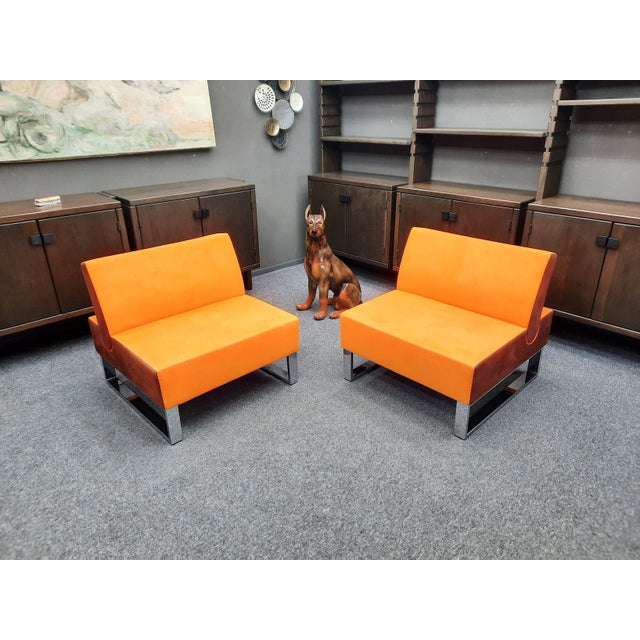 Two wonderful clubchairs by martin stoll. great color combination of orange and brown. the armchairs feature solid chrome...