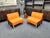 Two wonderful clubchairs by martin stoll. great color combination of orange and brown. the armchairs feature solid chrome...