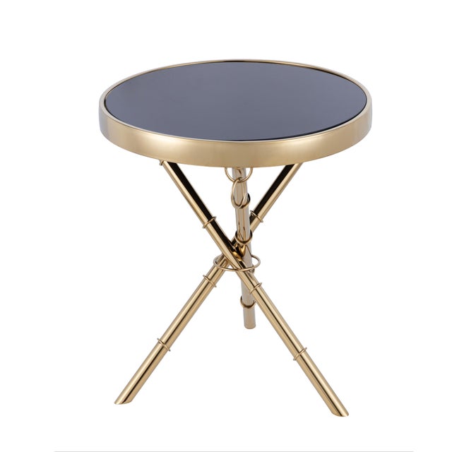 The Eloise Side Table features black tempered glass atop a gold-plated stainless steel frame, with ring details and subtly...