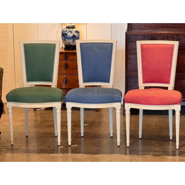 Six painted side chairs with upholstered seats and backs, currently covered in three different colors — two each in red,...