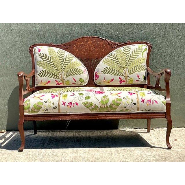This vintage carved wood settee beautifully combines refined craftsmanship with richly decorative textile artistry. The...
