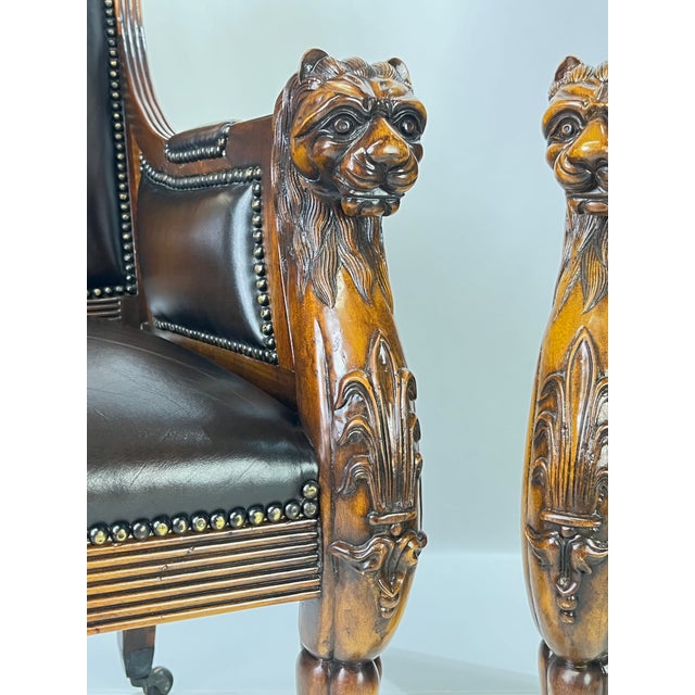 A stately pair of Regency style armchairs by Theodore Alexander. These exceptional chairs feature carved solid wood frames...