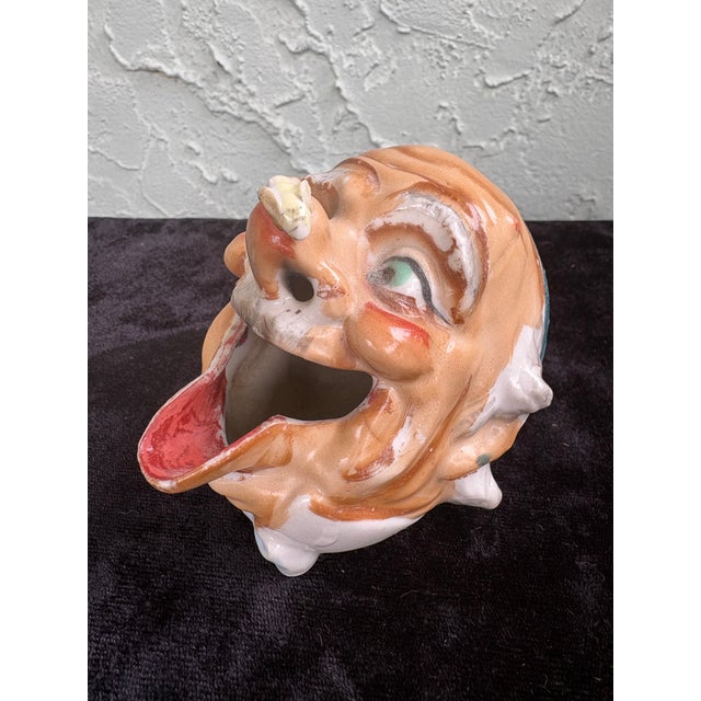 This vintage ceramic smoking head ashtray features a whimsical hobo / clown grotesque face with exaggerated facial...