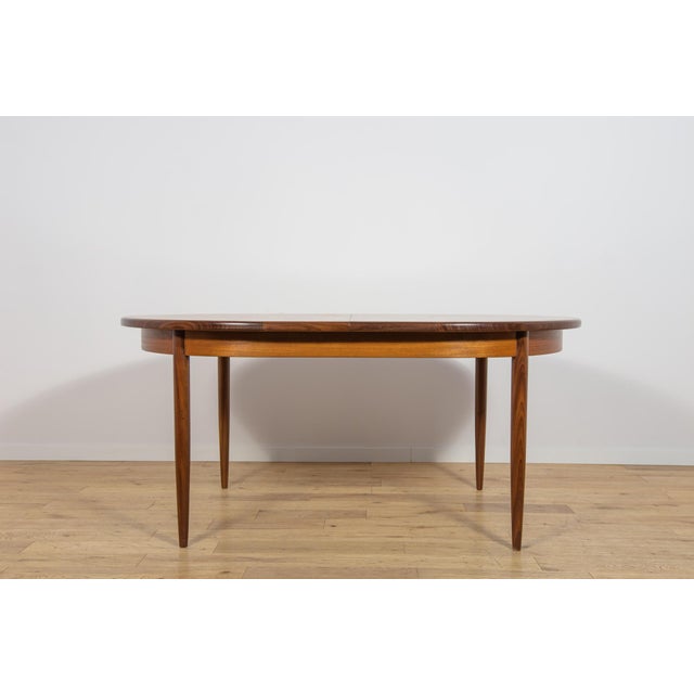 This extending dining table was manufactured by the British furniture maker G-Plan during the 1960s. The piece represents...