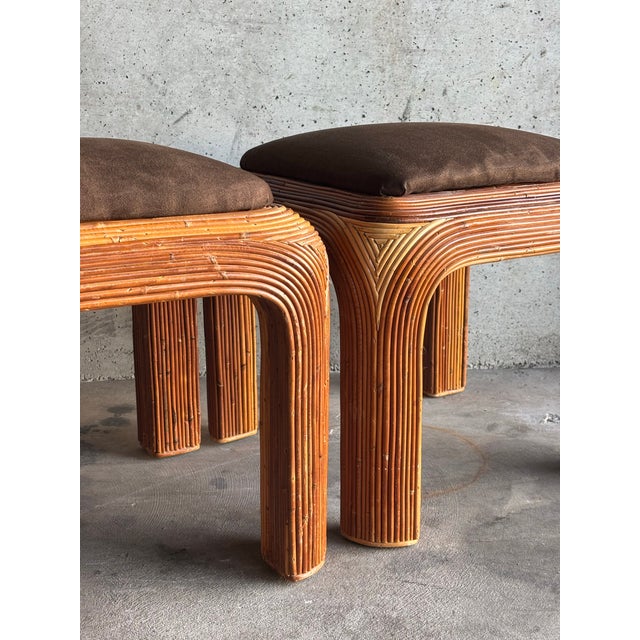 This elegant pair of vintage pencil reed stools or ottomans dates to the 1970s and showcases a sculptural four-leg...