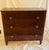 Flame Mahogany empire chest with three drawers below a curved single plank top two turned front feet