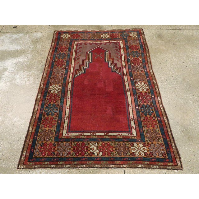 This Early 20th century Turkish Anatolian rug, measuring 3' 8" x 5' 5", is a striking example of the devotional weaving...