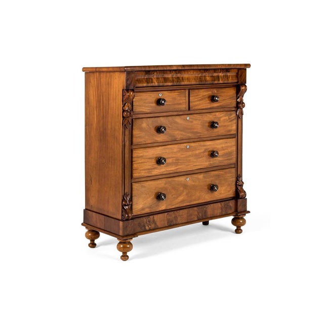 A tall and wide flamed mahogany victorian chest of drawers with an arrangement of two over three long drawers. The smooth...