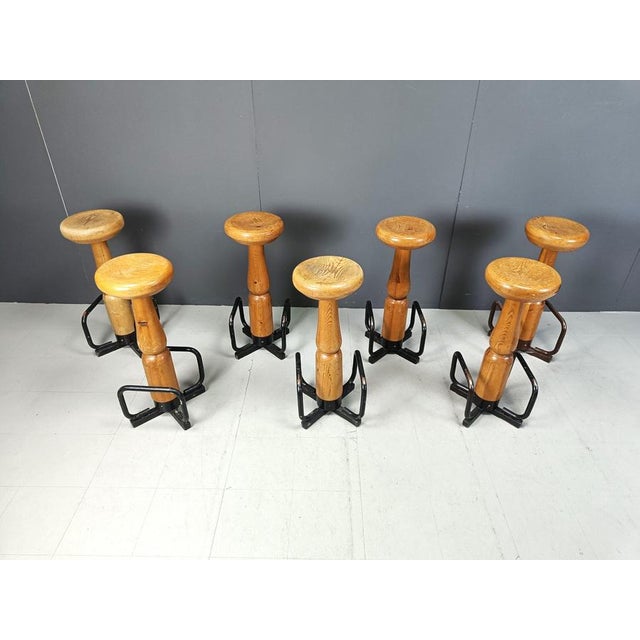 Solid wooden brutalist bar stools with a thick round seat and black steel footrests. Cool conical design, memphis style....